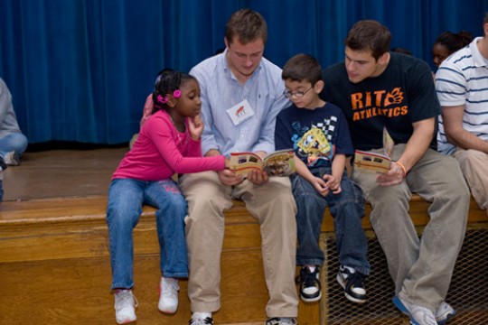Student reading books to kids
