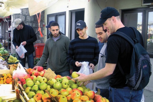 People looking at apples in market