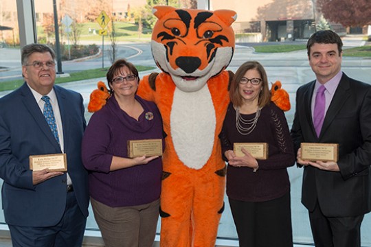 Four people posing with tiger mascot