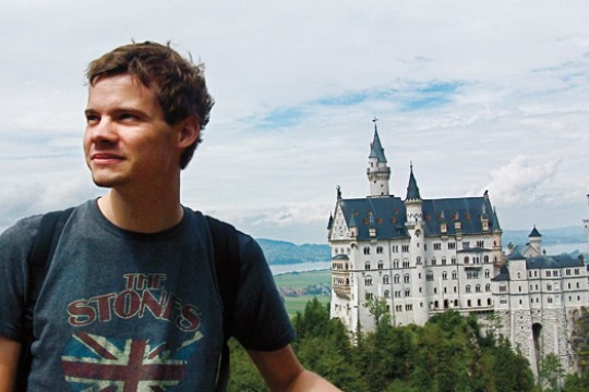 Person posing for camera in front of castle