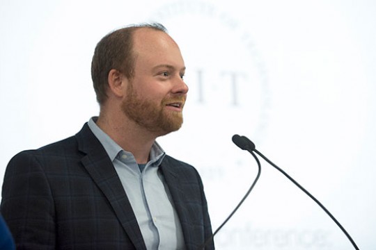 Austin McChord in front of podium microphone.
