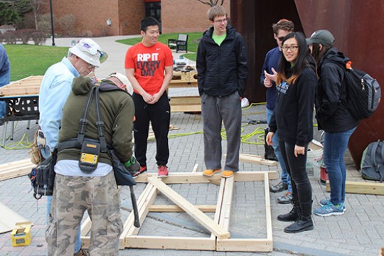 volunteers building framing for a house.
