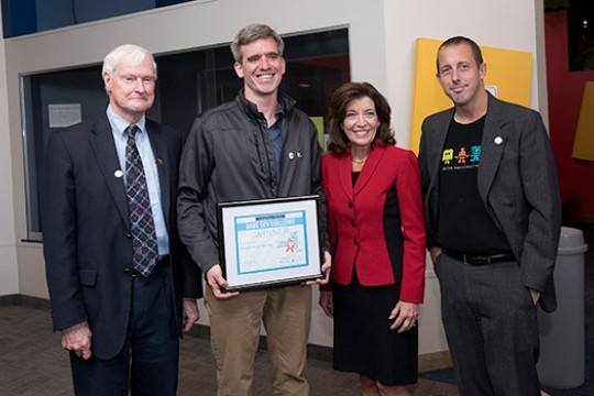 RIT President and professors posing with award