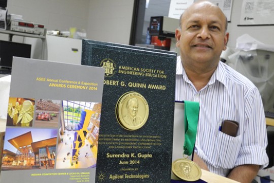 Professor posing with awards in lab
