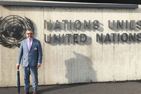 Peter Hauser standing in front of the United Nations sign.