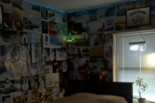 a dorm room with the walls covered in photos.