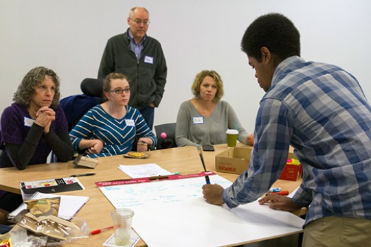 Tiree Walker presenting work for four other people at the RIT Access Technology IdeaLab.