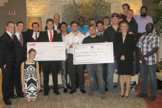 People gathered posing with two checks