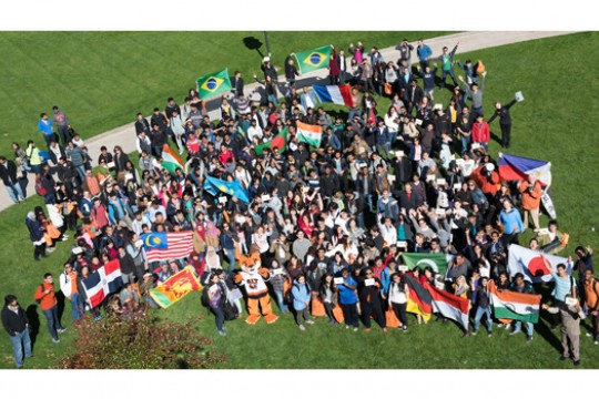 People gathered for picture with numerous flags