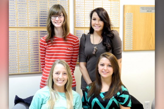 Four people posing for camera