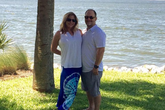 Sara and Jim Knight standing together in front of a body of water.
