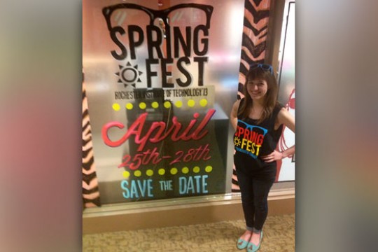 Person posing next to springfest poster