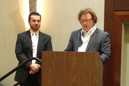 Two people speaking on stage