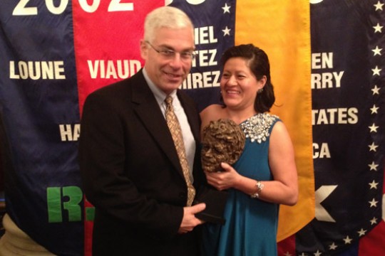 People posing with award at event