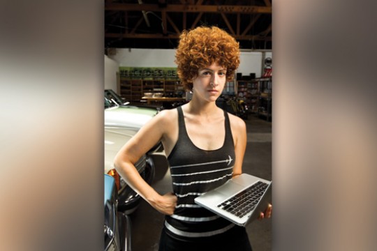 Person posing with computer in office