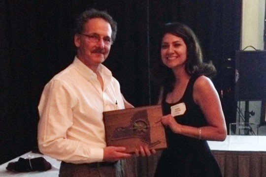 Two people posing with award