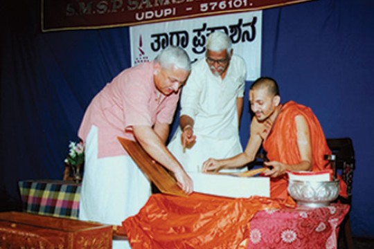 Three people looking at a book