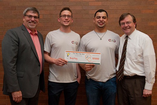 Professor and Students posing with check