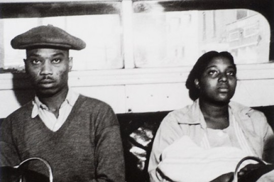 Old photo of two people sitting in segregated bus