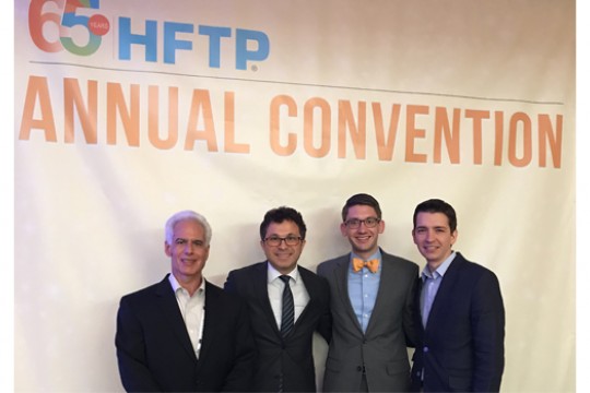 Linden Pohland poses for a photo with three other men at the HFTP Convention.