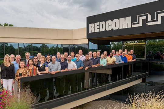 Members of REDCOM and RIT pose for a group photo outside the REDCOM office.