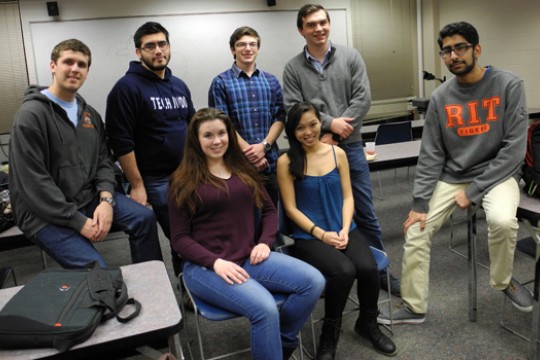 Team members pose for photo in classroom.