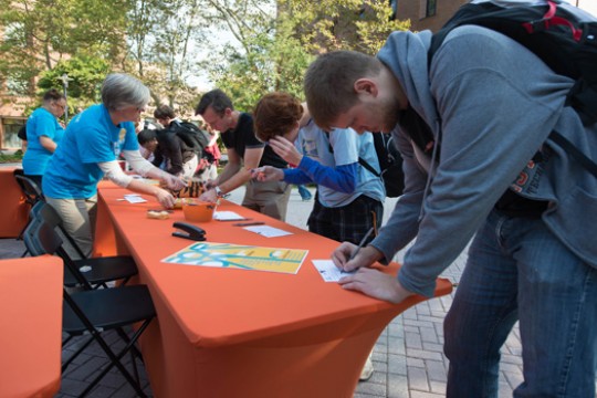 People signing cards at a table