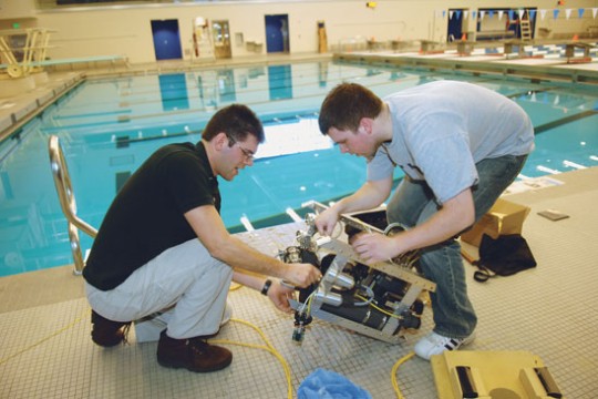 Students Working on Robot next to pool