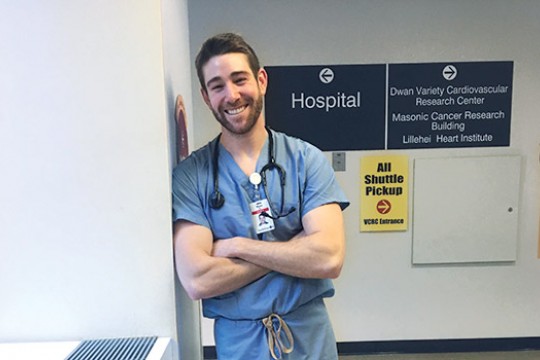 Ryan Buckley poses for a photo in his scrubs at a medical center.