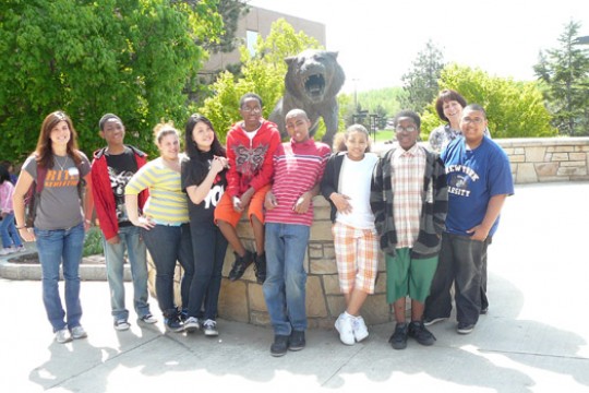 People posing for camera in front of tiger
