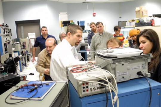 People gathered around machine in classroom