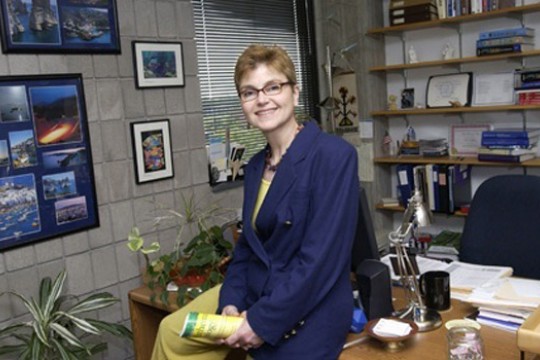 Professor sitting on desk in office