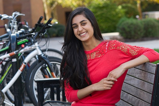 Person posing on bench next to bicycles
