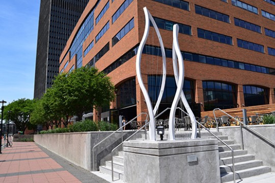 A sculpture sits outside a large building.
