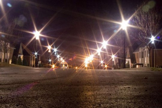 a walkway at night with bright streetlights.