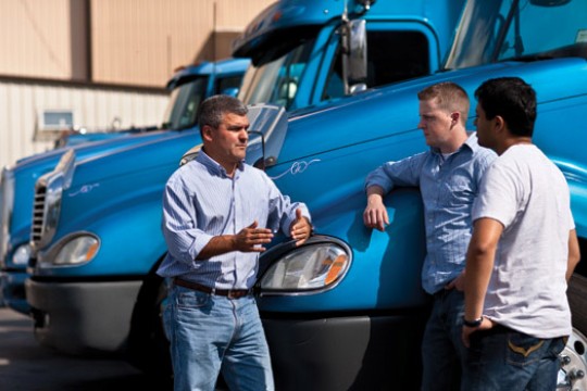 People posing for camera near truck