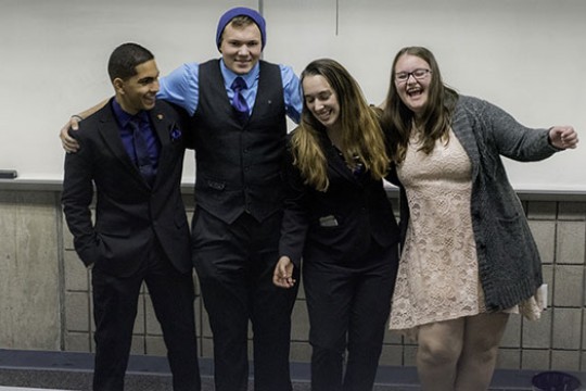 Four members of Alpha Phi Omega Xi Zeta chapter dressed up posing for picture.