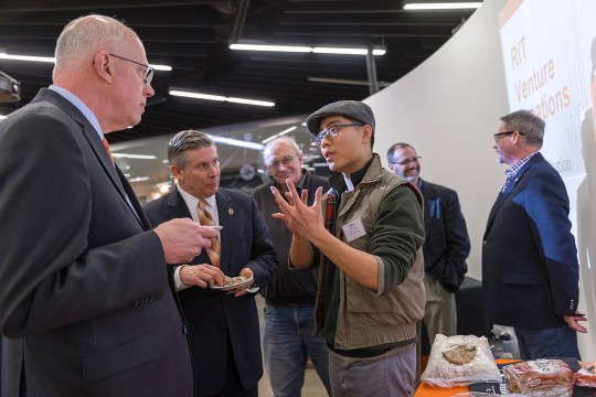 Student speaks with staff members at reception
