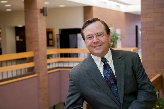 Man in suit poses in atrium