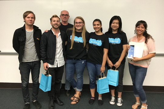 A group of people with EURKEA! shirts pose for a photo.