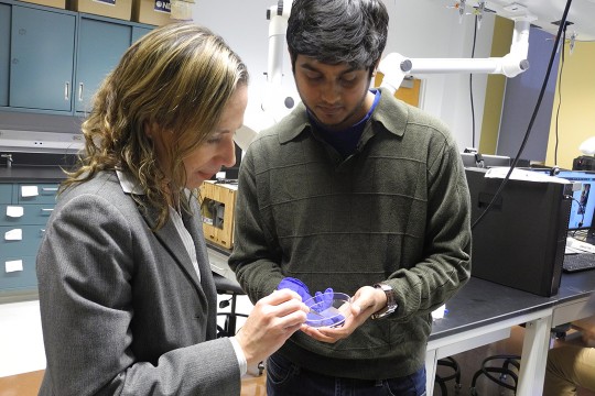 Faculty member and student hold petri dish