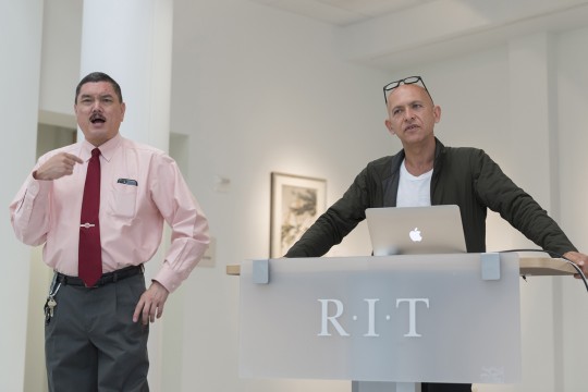 Man talks at podium with interpreter next to him