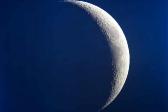 Photo of the crescent moon with deep blue nighttime sky