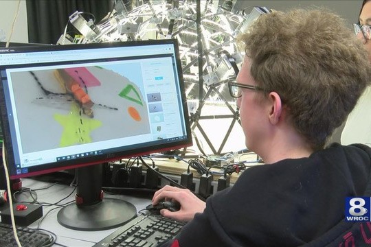 Woman looks at computer screen with insect. 