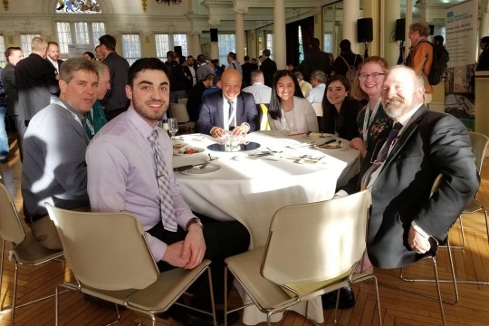 Group of people sits at banquet table.