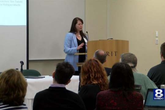 Researcher speaks at podium.