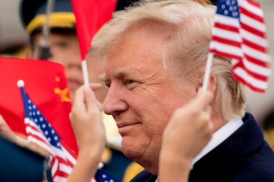 Close-up of Donald Trump's face with American and Chinese flags.