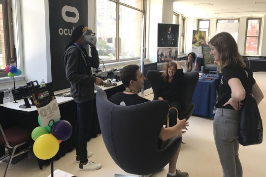 People sitting and standing in open-concept office space.