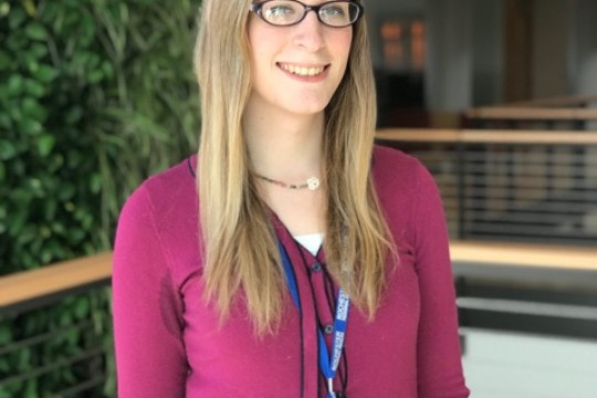 Student standing in front of green wall