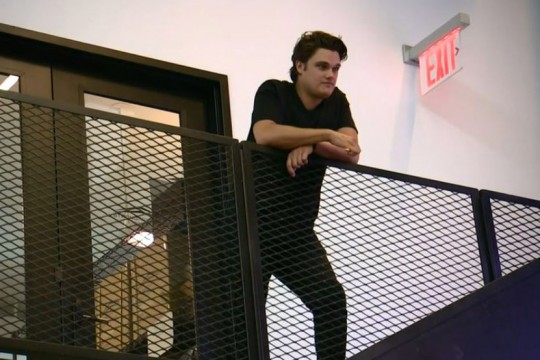 Man stands at top of stairwell.